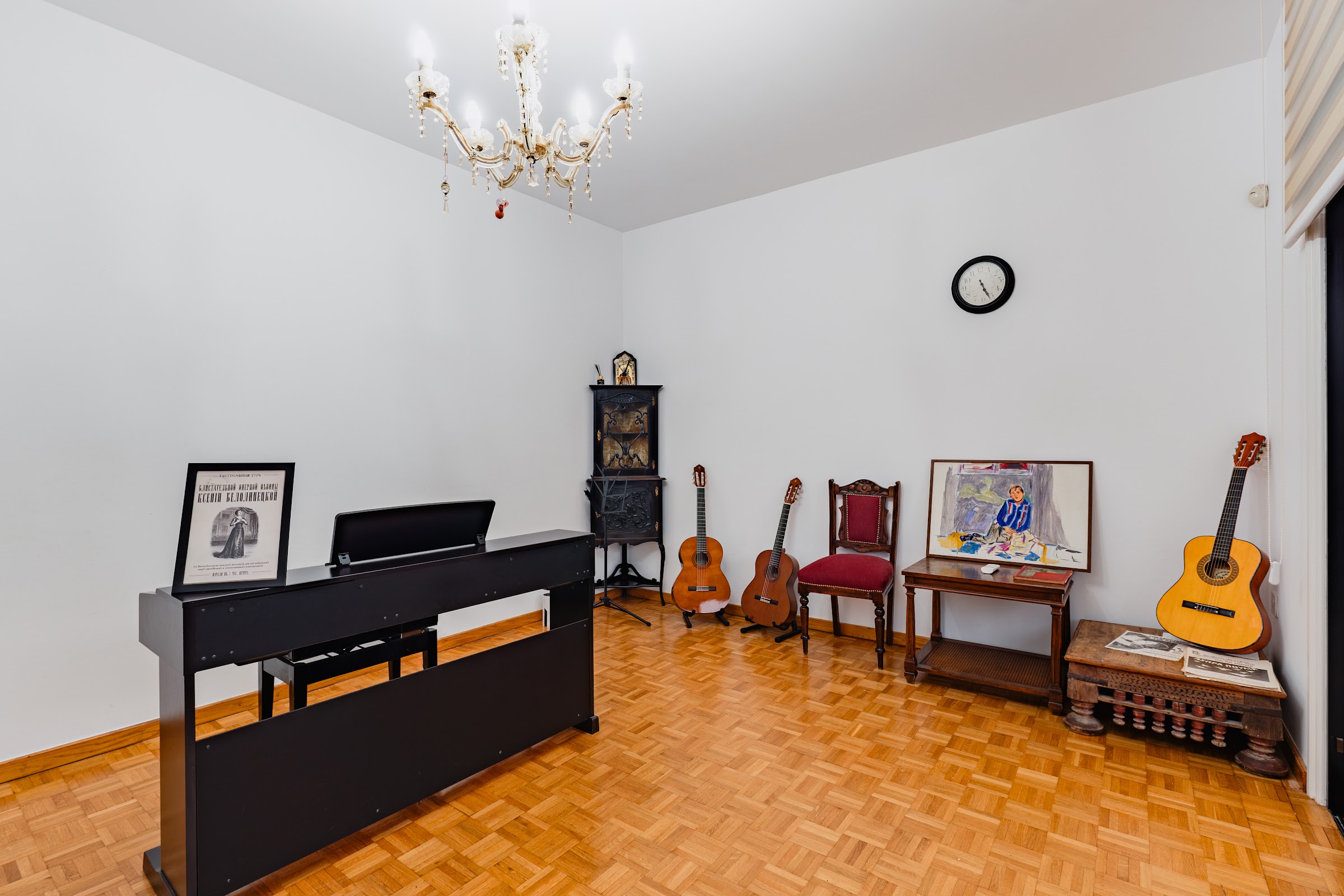 Practice room with digital keyboard, classical guitars, crystal chandelier, and music memorabilia