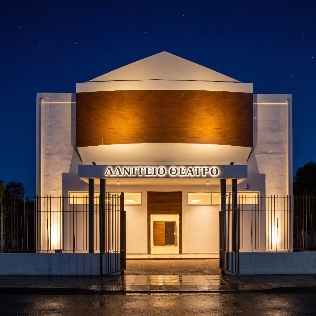 Laniteio Theatre entrance: illuminated signage, black columns, warm amber light spilling through the glass doors