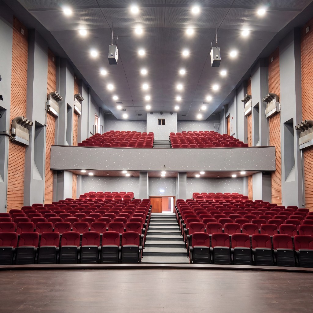 Laniteio Theatre auditorium from the stage: 500 red velvet seats, balcony, professional stage lighting